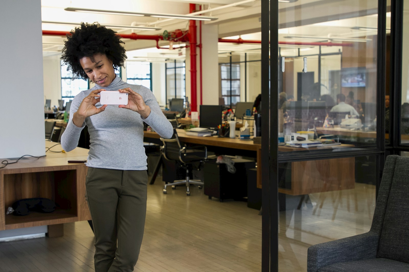 a woman walking through an office holding a box